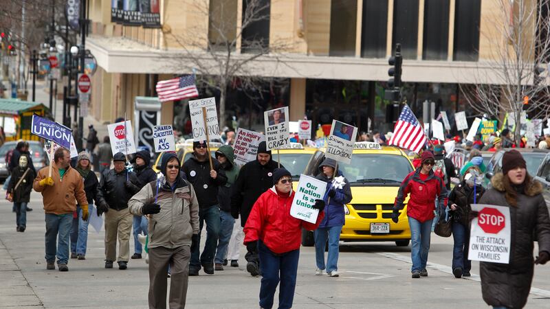 FILE - Pro-union protesters march around the the Wisconsin state Capitol in Madison, Wis.,...