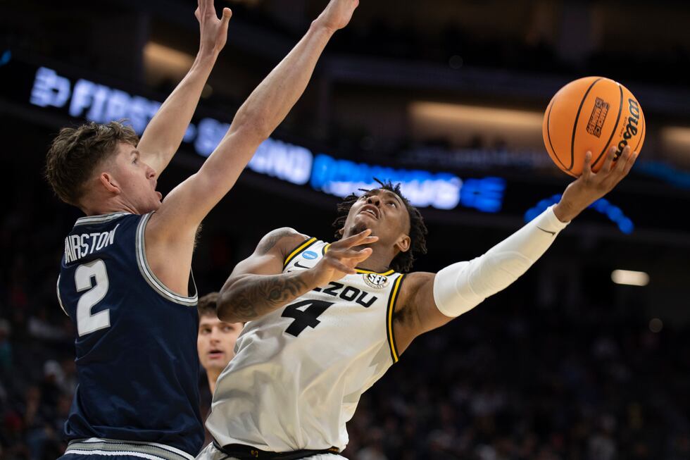 Missouri guard DeAndre Gholston (4) shoots around Utah State guard Sean Bairstow (2) during...