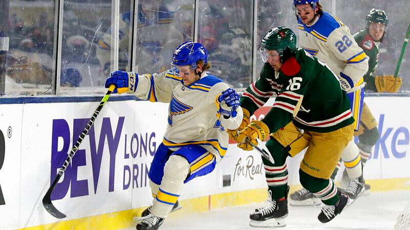 St. Louis Blues defenseman Scott Perunovich, left, and Minnesota Wild center Rem Pitlick (16)...