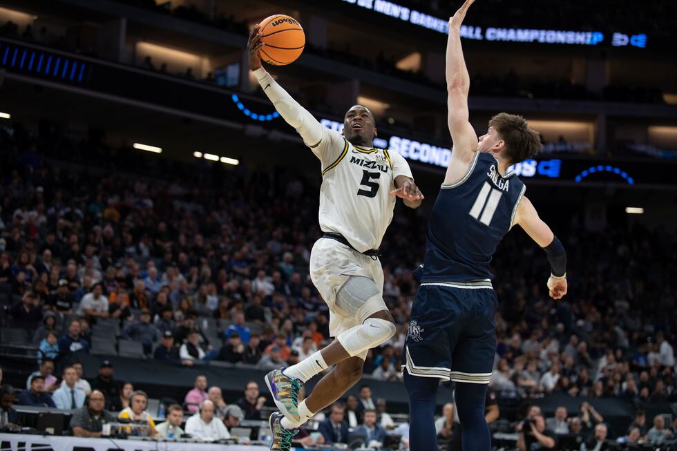 Missouri guard D'Moi Hodge (5) scores past Utah State guard Max Shulga (11) during the first...